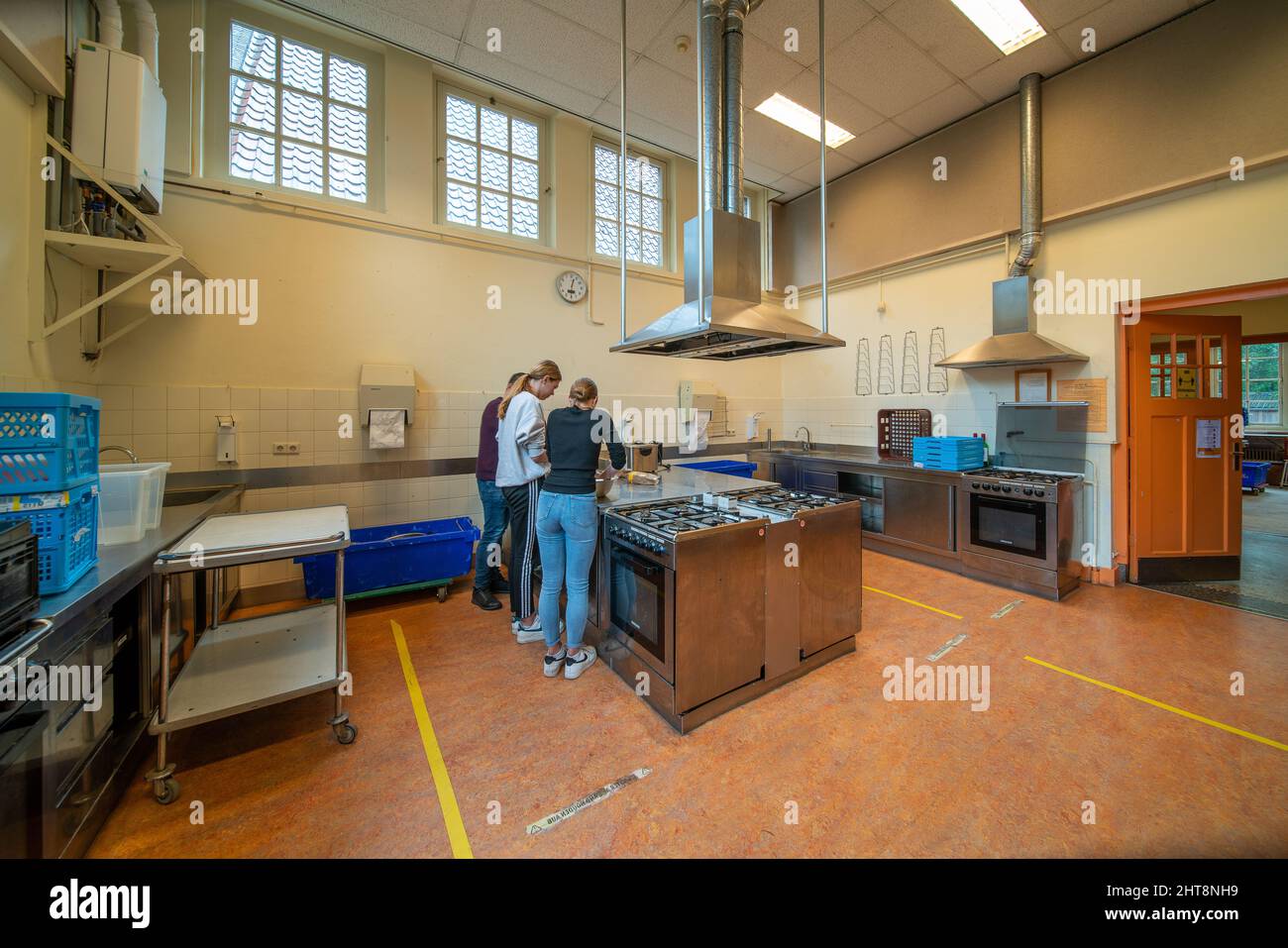 On apprend aux enfants à cuisiner dans une salle de cuisine de l'école primaire Banque D'Images