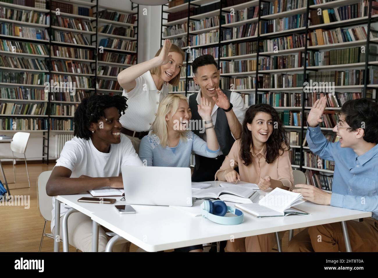 Jeunes étudiants multiethniques joyeux qui se donnent cinq élèves les uns aux autres. Banque D'Images