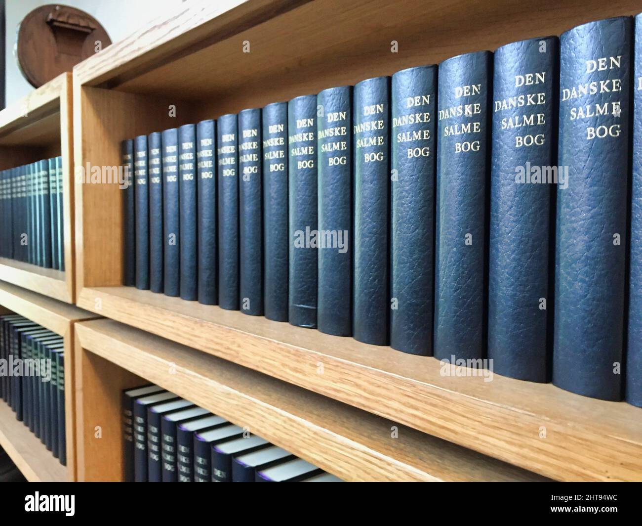 Une rangée de livres bleus d'hymnes danois dans une bibliothèque Banque D'Images