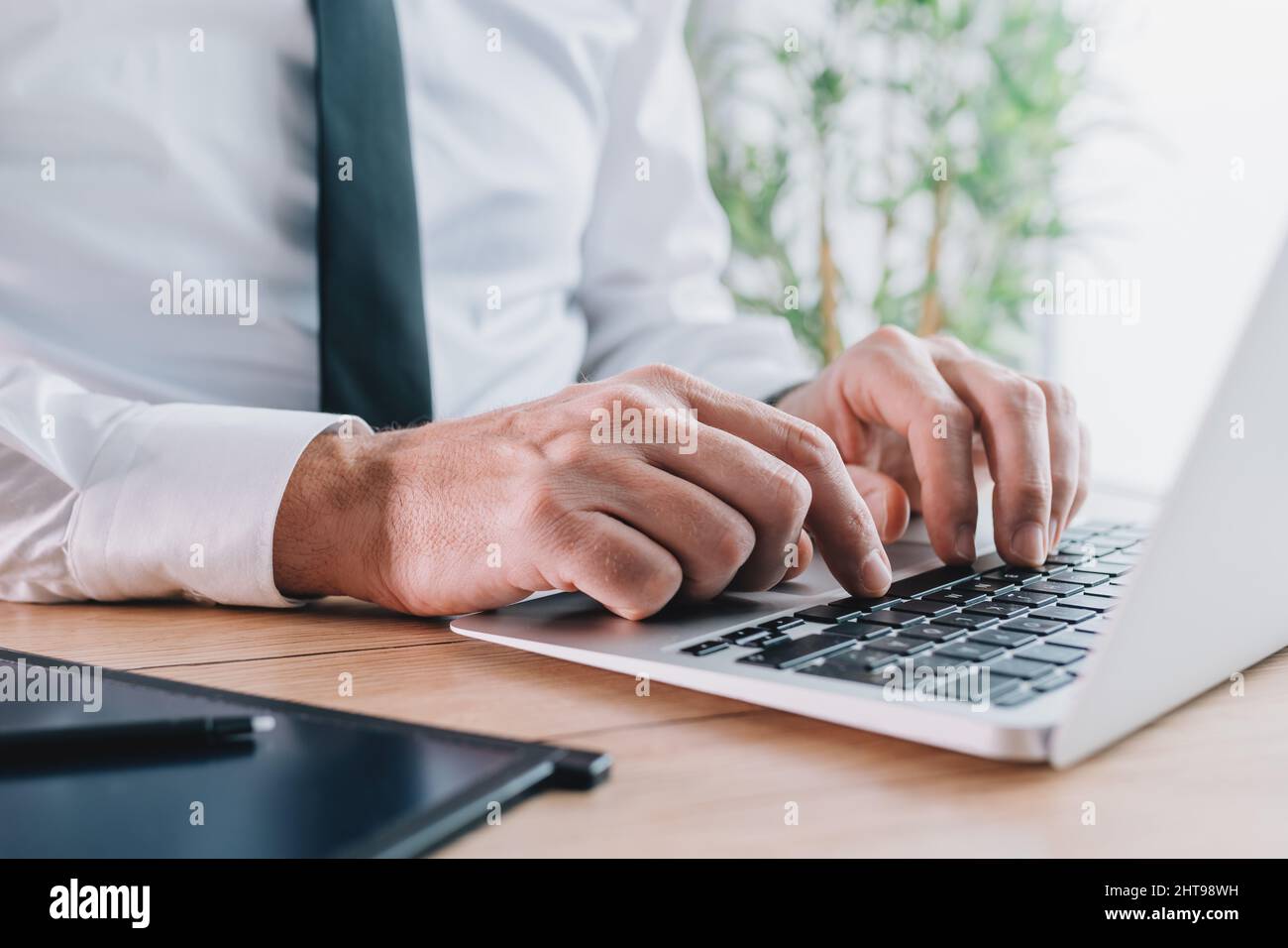 Agent de banque dactylographiant ordinateur portable clavier au bureau, foyer sélectif Banque D'Images