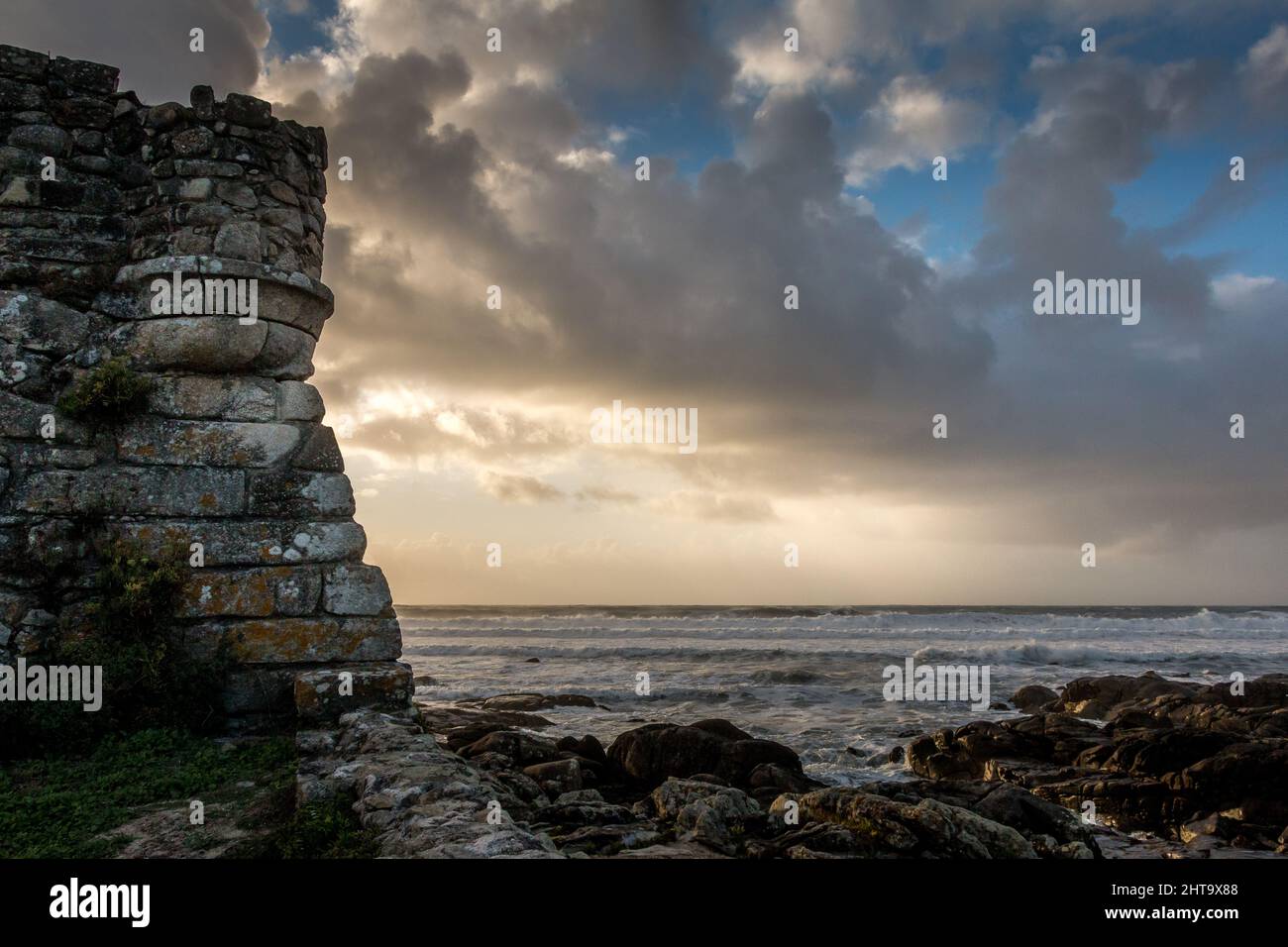 Une belle vue sur la mer avec un ciel nuageux et un vieux mur Banque D'Images
