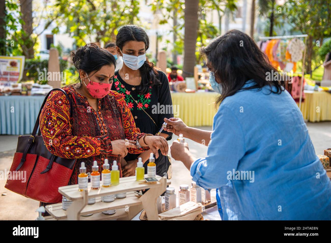 New Delhi, Inde. 27th févr. 2022. Les femmes testent le parfum tout en faisant des achats dans un marché du dimanche organisé par Bikaner House Management Society à New Delhi. Le 26 2022 février, le gouvernement de Delhi a levé toutes les restrictions de la COVID-19 en raison de la diminution du nombre d'infections à coronavirus. Crédit : SOPA Images Limited/Alamy Live News Banque D'Images