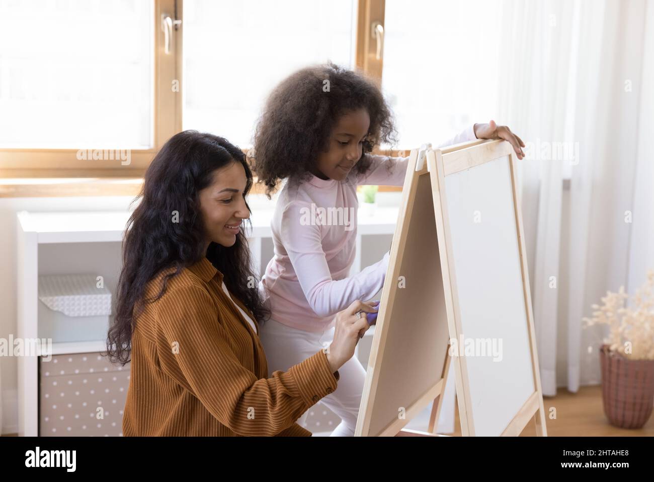 Bonne adhésion de la famille afro-américaine à dessiner sur tableau blanc. Banque D'Images