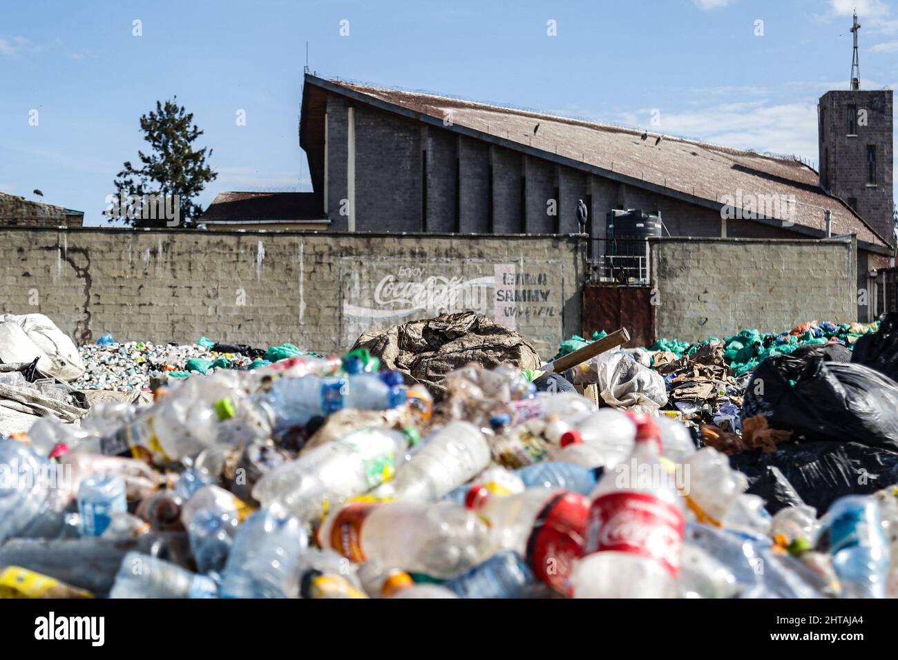 Nairobi, Kenya. 1st décembre 2021. Une vue d'un tas de déchets de bouteilles en plastique devant un mur peint avec le logo de CocaCola.les discussions pour définir une voie à suivre pour un traité mondial sur la matière plastique pour résoudre le problème croissant de la pollution plastique sont sur le point de commencer cette semaine pendant l'Assemblée de l'environnement des Nations Unies UNEA 5,2). Avec deux projets de résolution sur la table, les pays membres décideront soit d'aborder le cycle de vie complet des plastiques tel que proposé par le Rwanda et le Pérou, soit d'aller avec le projet de résolution du Japon qui met l'accent sur une meilleure gestion des déchets plastiques. Plus de 50 pays et e Banque D'Images