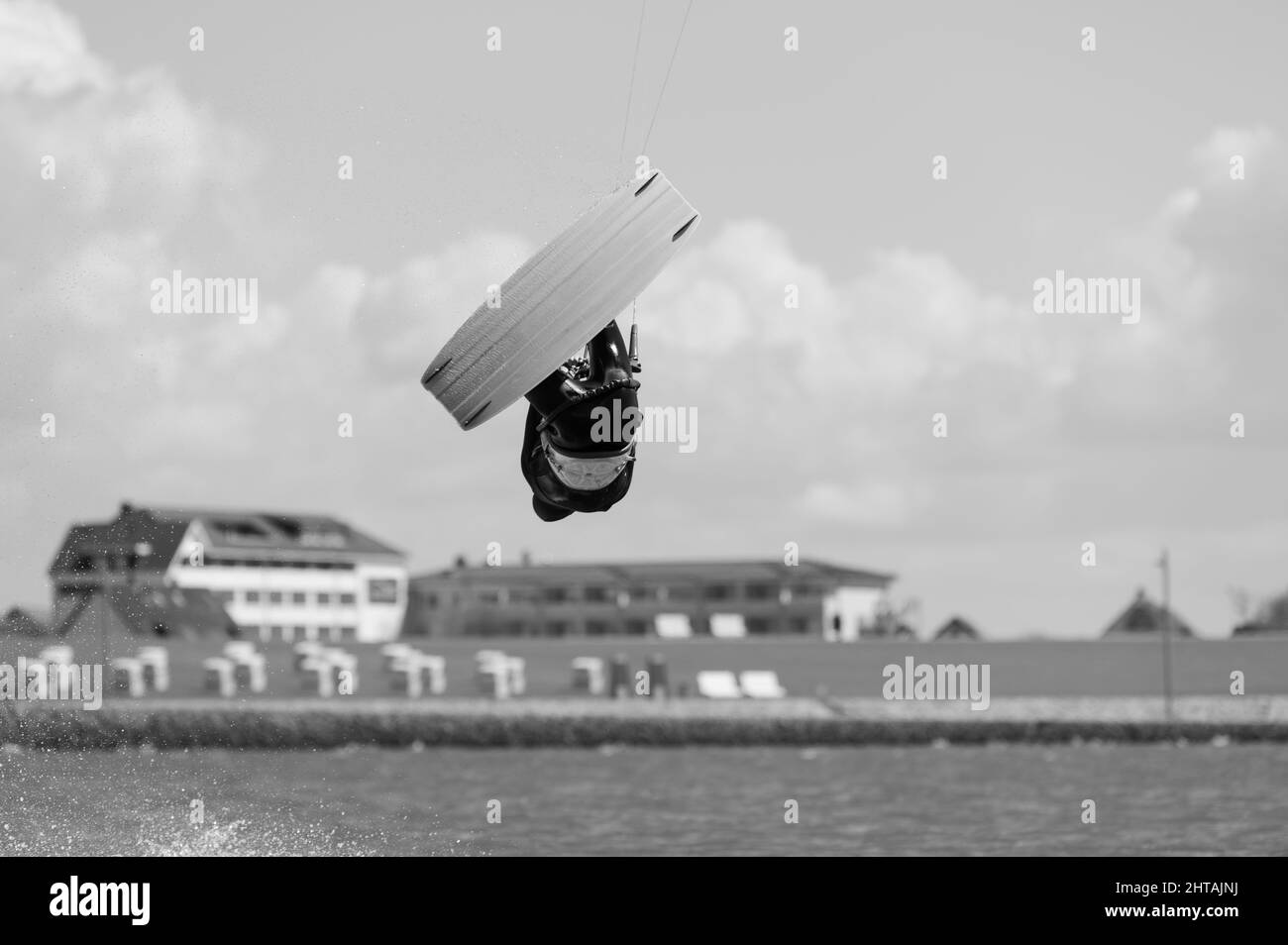 Prise de vue en niveaux de gris d'un kite surfeur contre un ciel nuageux Banque D'Images