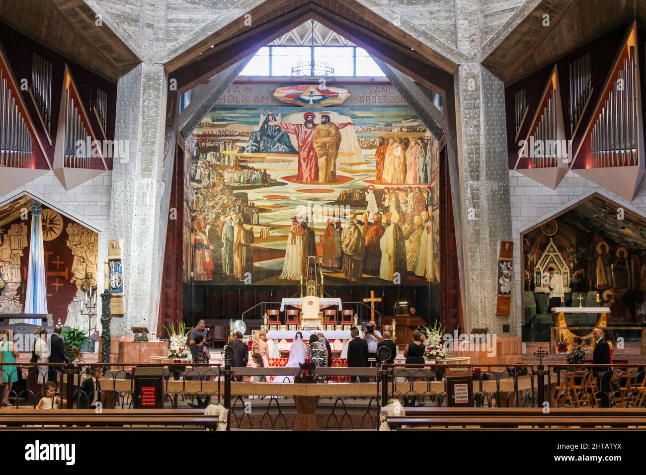 Une cérémonie chrétienne de mariage se déroule sous une grande mosaïque dans la haute église de la Basilique de l'Annonciation à Nazareth, Israël. Banque D'Images