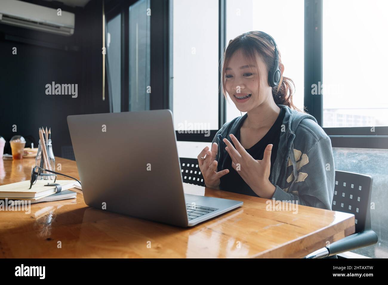 Une étudiante étudie dans le café-restaurant. Elle utilise un ordinateur portable et apprend en ligne pour l'examen universitaire Banque D'Images