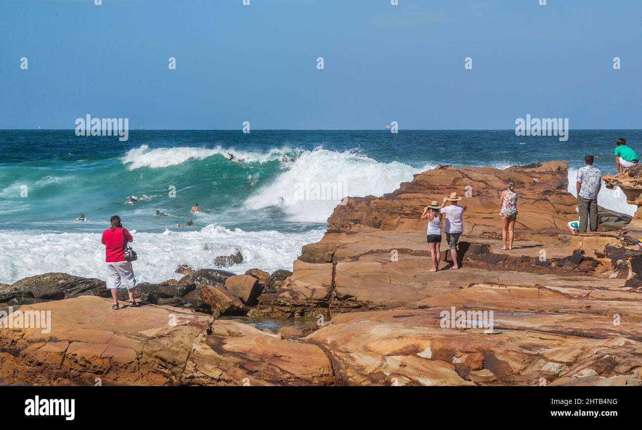 Les spectateurs regardent les surfeurs du diable dans des vagues tumultueuses à Avoca Beach, Central Coast, Nouvelle-Galles du Sud, Australie Banque D'Images