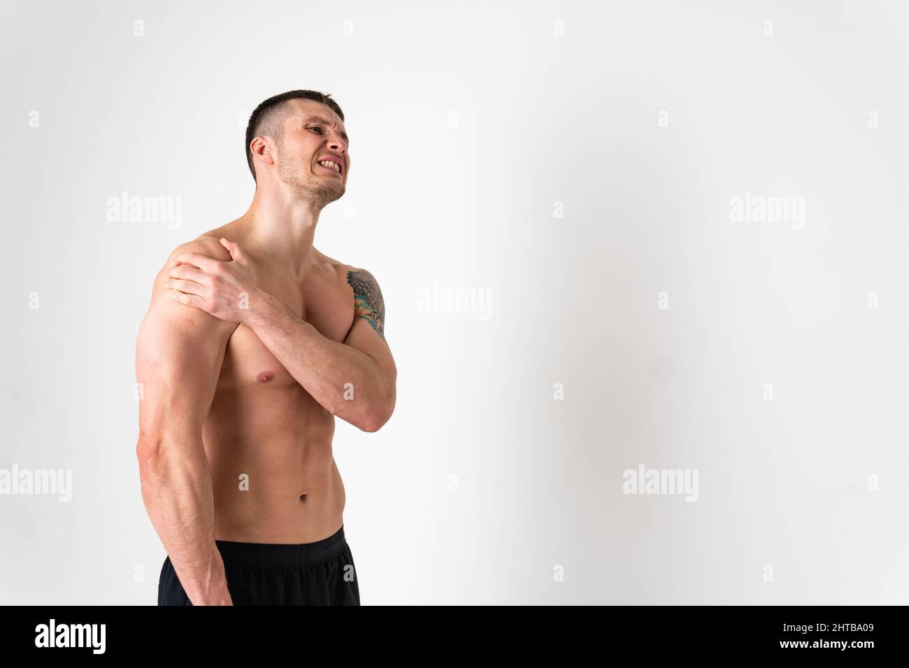 Un muscle douloureux de l'articulation de l'épaule chez un homme blanc sur fond blanc blessure blessée, malade médical, tenue musculaire. Tension rouge soins, la maladie souffrent Banque D'Images