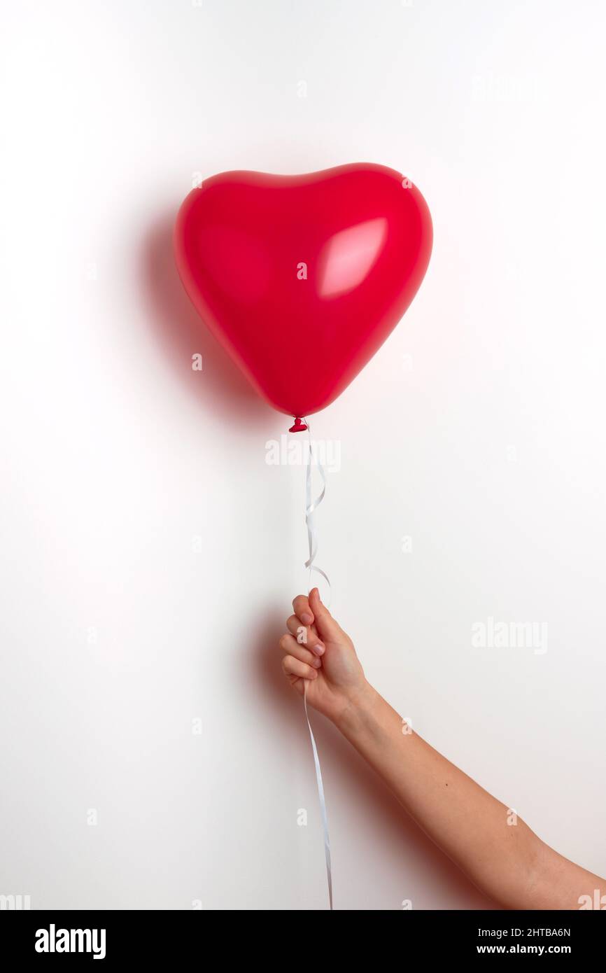 Ballon gonflable à l'hélium en forme de coeur pour la Saint-Valentin sont  tenus par une fille dans sa main. Vue avant Photo Stock - Alamy