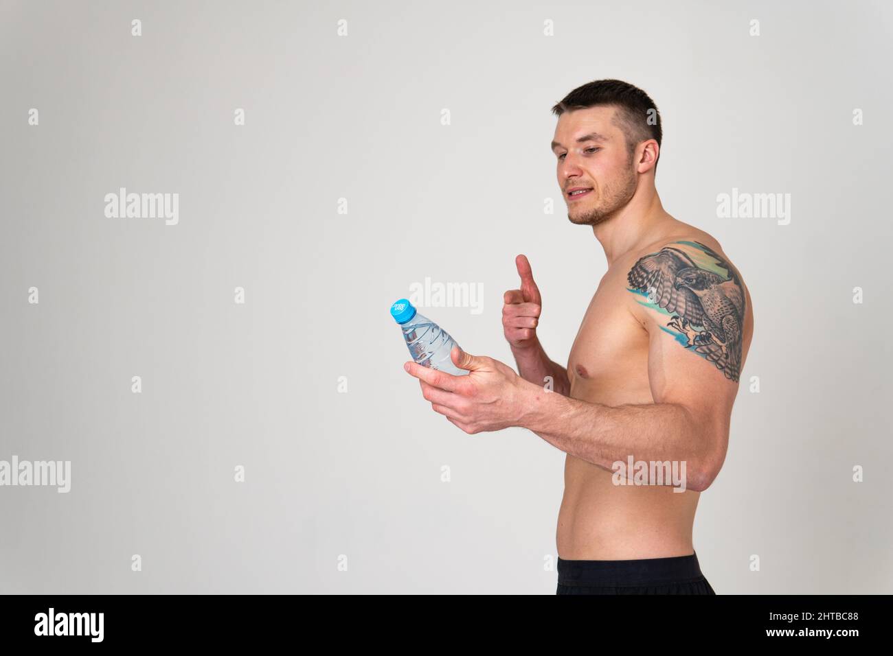 Homme boire-eau fitness est pompé avec une serviette sur un fond blanc isolé ajustement musculaire entraînement sport alimentation de gym gars, break athlétique. Force Banque D'Images