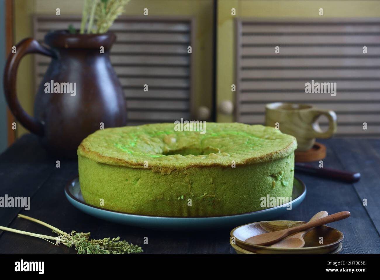 Gâteau au mousseline de Bolu pandan ou de Pandan, servi avec du thé sur fond de bois sombre. Mise au point sélective. Banque D'Images