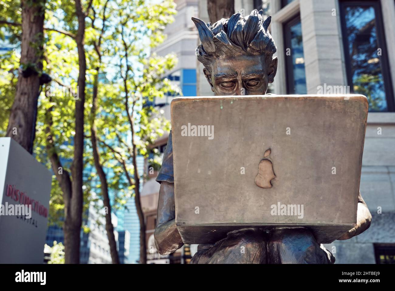 Juin 2018 - Montréal, Canada : statue étudiante de l'Université McGill assise sur un banc et utilisant un ordinateur portable dans la rue Sherbrooke à Montréal, Québec, CAN Banque D'Images