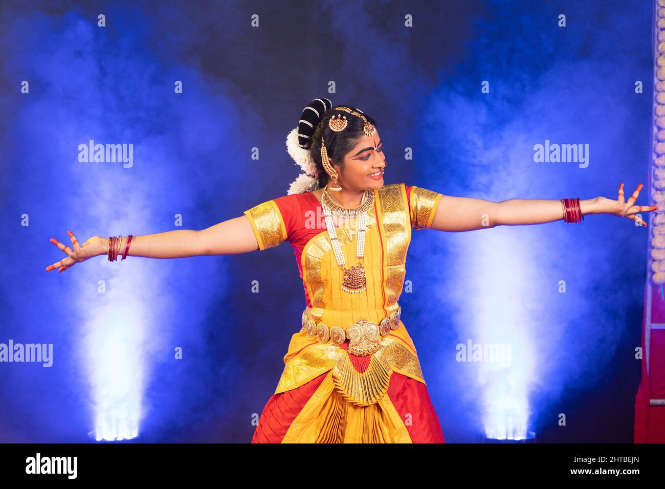 Danseuse indienne souriante bharatanatyam sur scène dansant avec les mains gestuelle - adepte de l'artiste, de la culture indienne traditionnelle et danseuse clasique. Banque D'Images