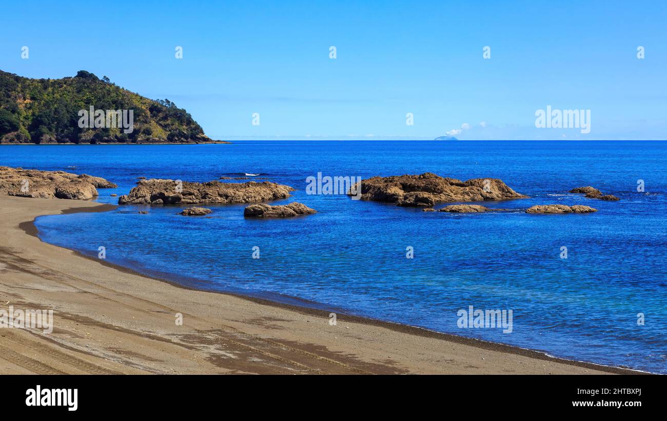 La plage d'Omaio, un endroit isolé dans l'est de la baie de Plenty, en Nouvelle-Zélande. White Island, un volcan, vole à l'horizon Banque D'Images