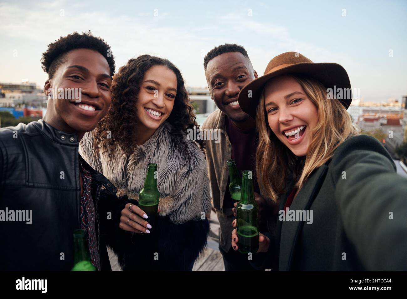 Portrait d'un groupe attrayant de jeunes adultes multiculturels qui se réunissent sur un toit-terrasse de la ville. Banque D'Images