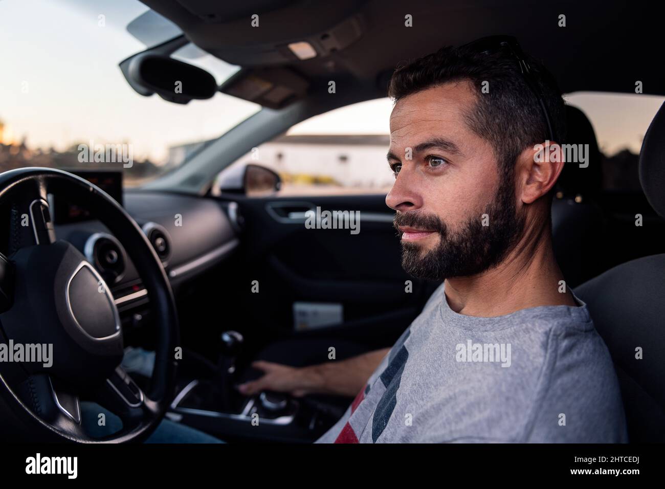 beau jeune homme assis au volant de sa voiture, de ses loisirs et de son concept de conduite Banque D'Images