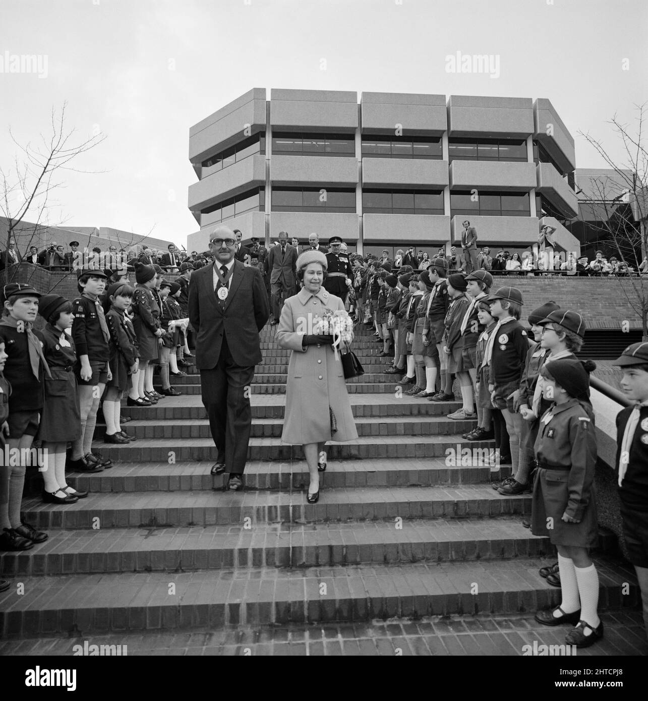 Shire Hall, Shinfield Park, Shinfield, Wokingham, 02/04/1982. La reine Elizabeth II et le président du conseil du comté de Berkshire descendant un vol de marches bordé de Brownies et de scouts Cub à l'ouverture du Shire Hall. La région sud de Londres de Laing a commencé à travailler au Shire Hall, le nouveau siège du Conseil du comté de Berkshire, à Shinfield Park au début de 1976. Le bâtiment a été achevé en 1980 et l'ouverture officielle a eu lieu en avril 1982. Lors de l'ouverture officielle, à laquelle assistaient la reine Elizabeth II, le prince Philip et Lewis Moss, président du conseil du comté de Berkshire, il y avait 5000 personnes locales Banque D'Images