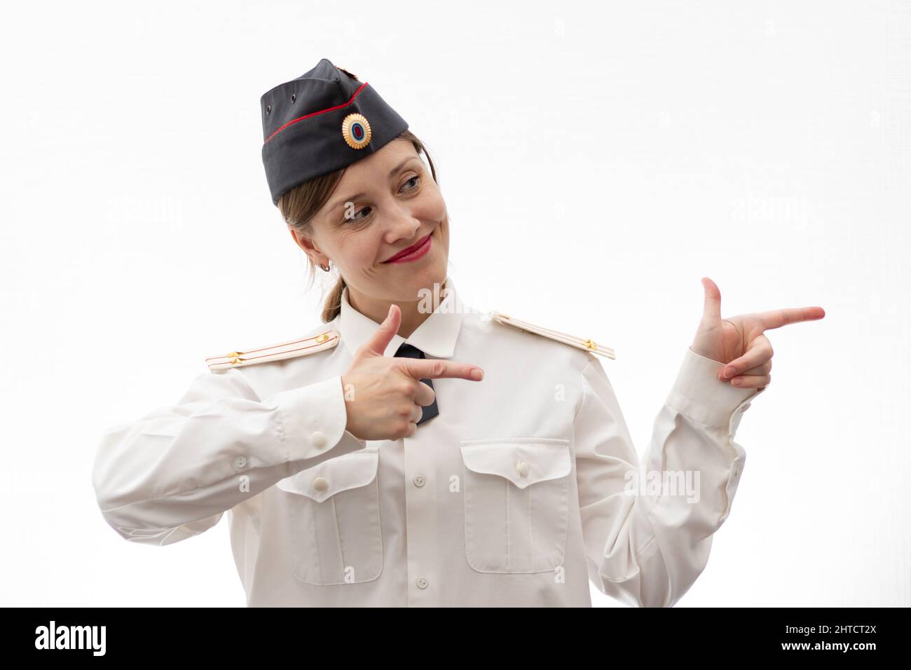 Belle jeune femme de police russe en uniforme montre des signes avec ses mains sur un fond blanc. Mise au point sélective. Portrait Banque D'Images