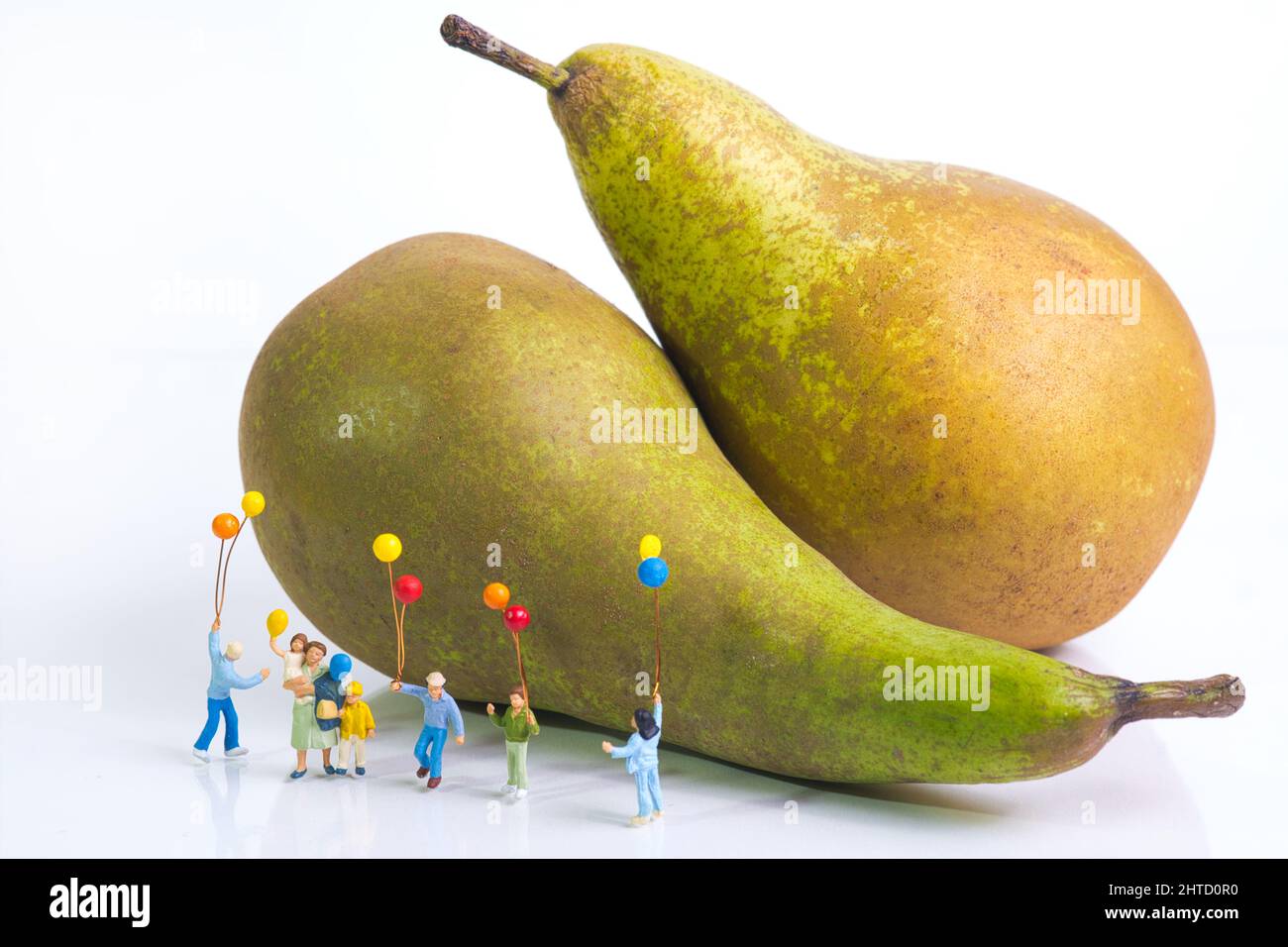 Une mère avec des enfants gaies est debout avec des ballons colorés devant des poires Banque D'Images