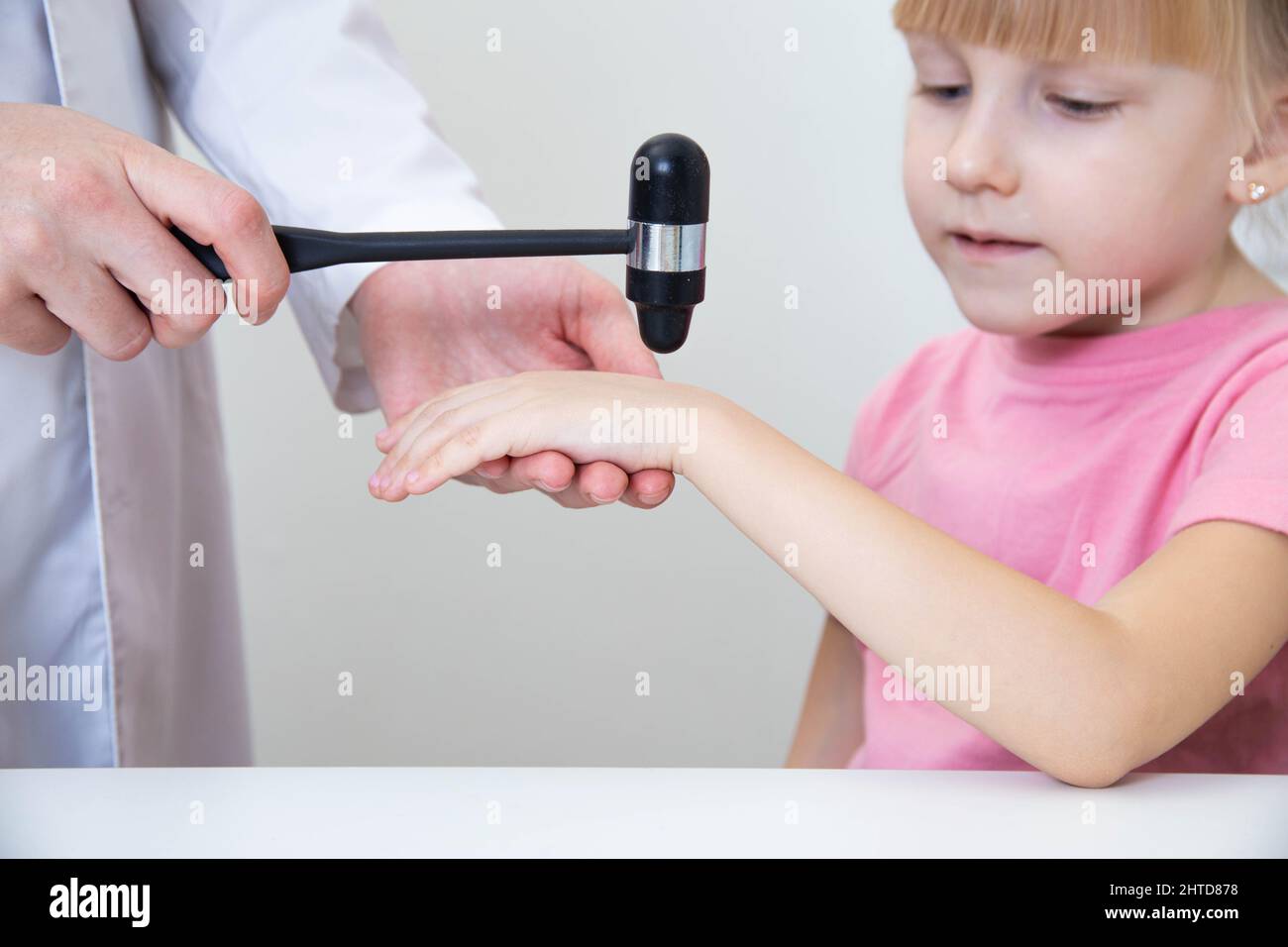 Un neuropathologiste vérifie les réflexes sur le poignet d'une petite fille de 5 ans. Banque D'Images