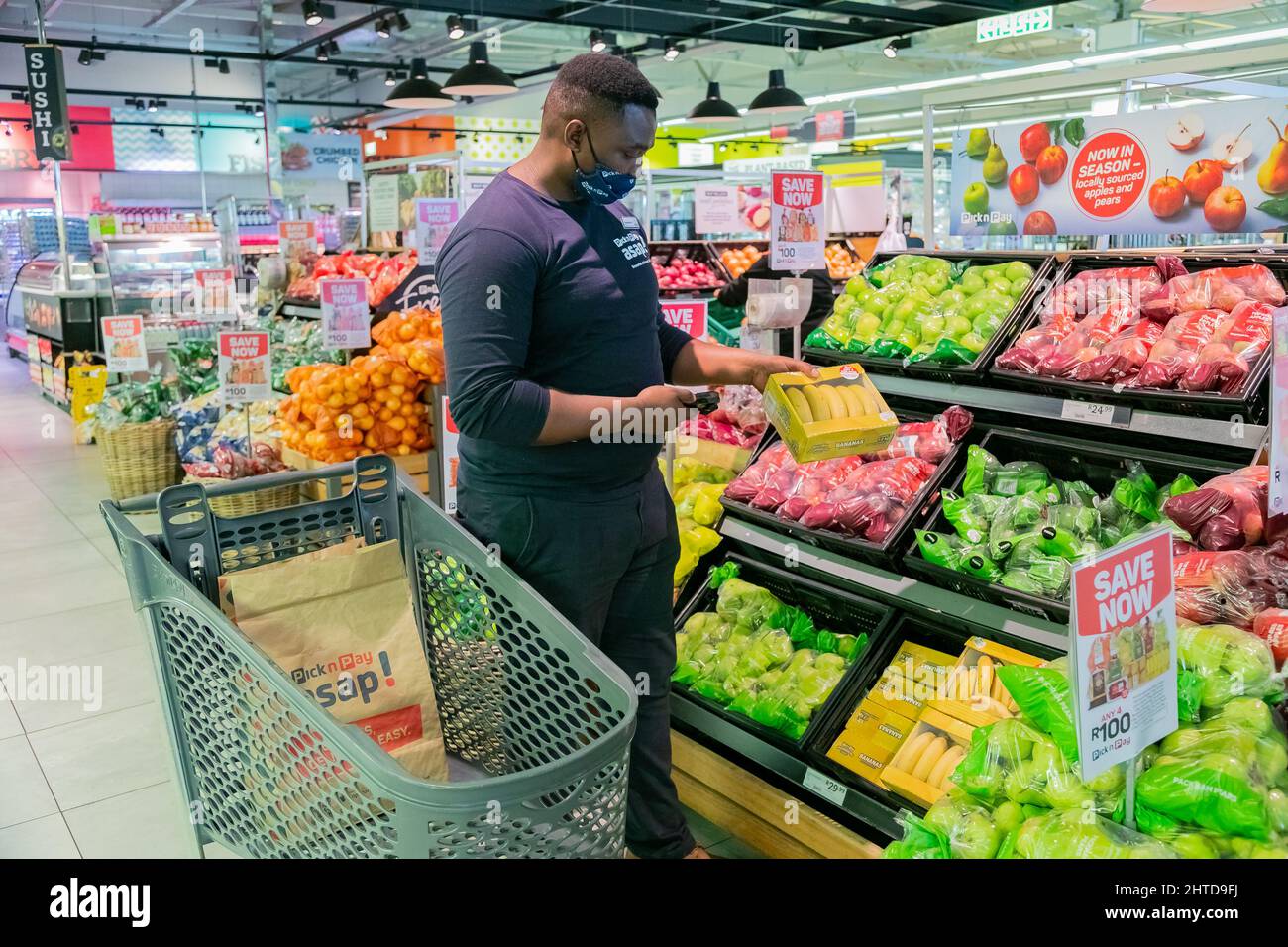 Cape Town, Afrique du Sud - 9 septembre 2021 : un membre du personnel cueille des produits à partir de l'étagère pour un service de livraison express à domicile Banque D'Images