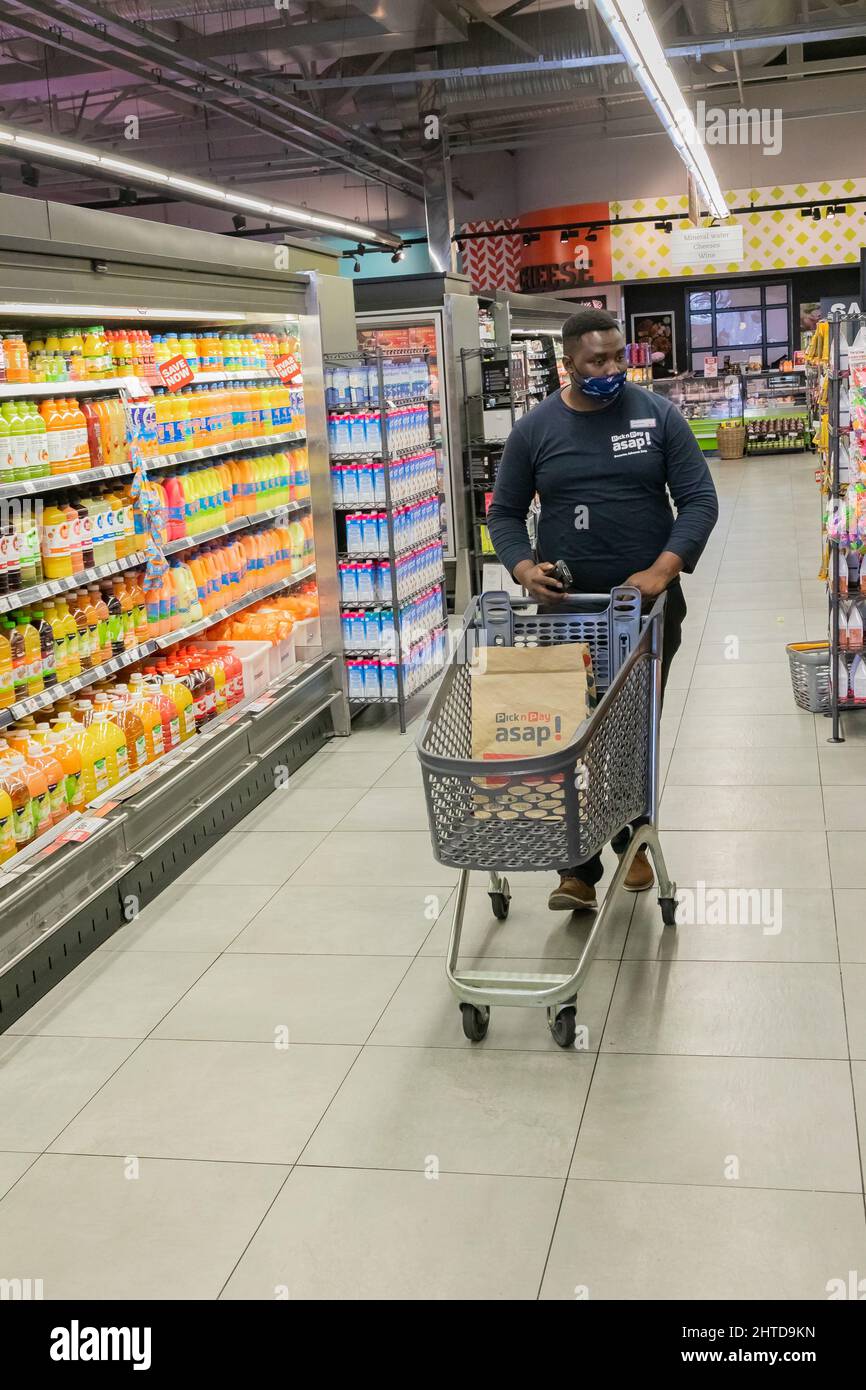 Cape Town, Afrique du Sud - 9 septembre 2021 : un membre du personnel cueille des produits à partir de l'étagère pour un service de livraison express à domicile Banque D'Images