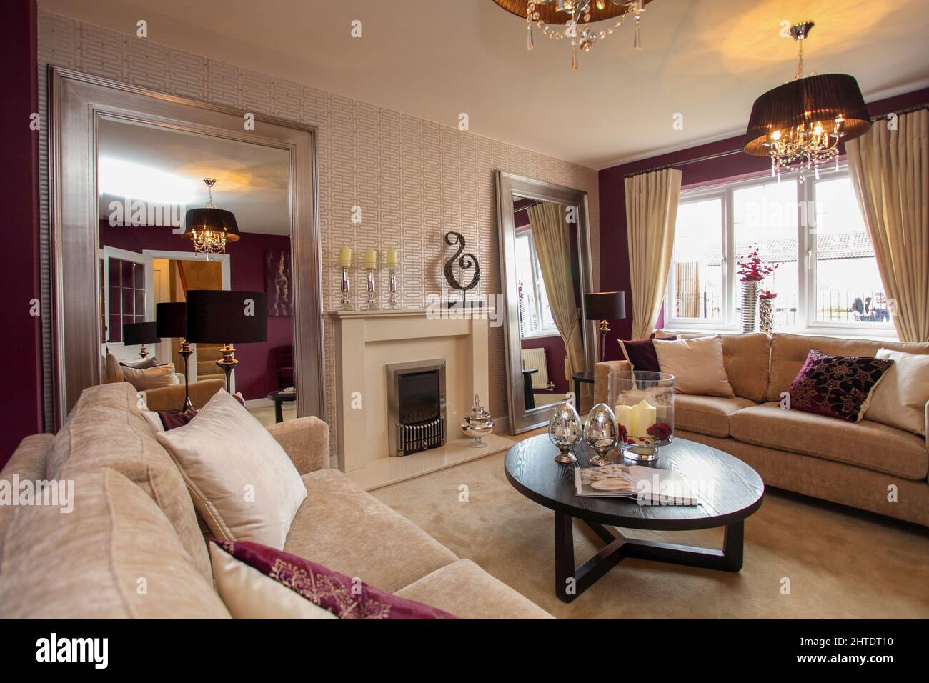 Salon moderne salon dans maison neuve, moquette beige et canapé-lit, violet, rouge foncé, murs bordeaux, table basse. Banque D'Images