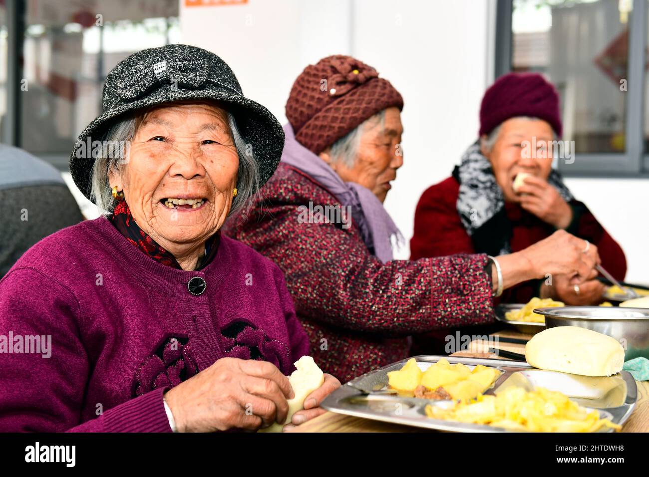 JINAN, le 28 février 2022 (Xinhua) -- les personnes âgées profitent de leur déjeuner dans un centre de soins pour les personnes âgées du village de Huangjiayu, district de Lanshan, Rizhao, province de Shandong en Chine orientale, le 27 février 2022. Le district de Lanshan de la ville de Rizhao a mis en place des centres de soins depuis 2021, fournissant assistance et soins aux personnes âgées de plus de 60 ans. (Xinhua/Guo Xulei) Banque D'Images