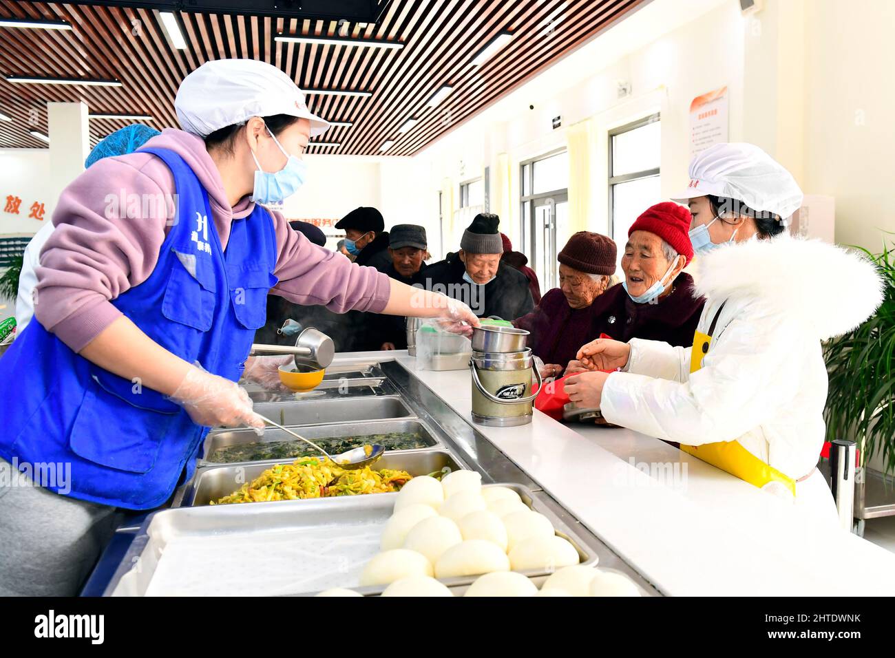 JINAN, le 28 février 2022 (Xinhua) -- des bénévoles servent le déjeuner dans un centre de soins communautaires pour les personnes âgées du district de Lanshan, Rizhao, dans la province de Shandong en Chine orientale, le 27 février 2022. Le district de Lanshan de la ville de Rizhao a mis en place des centres de soins depuis 2021, fournissant assistance et soins aux personnes âgées de plus de 60 ans. (Xinhua/Guo Xulei) Banque D'Images