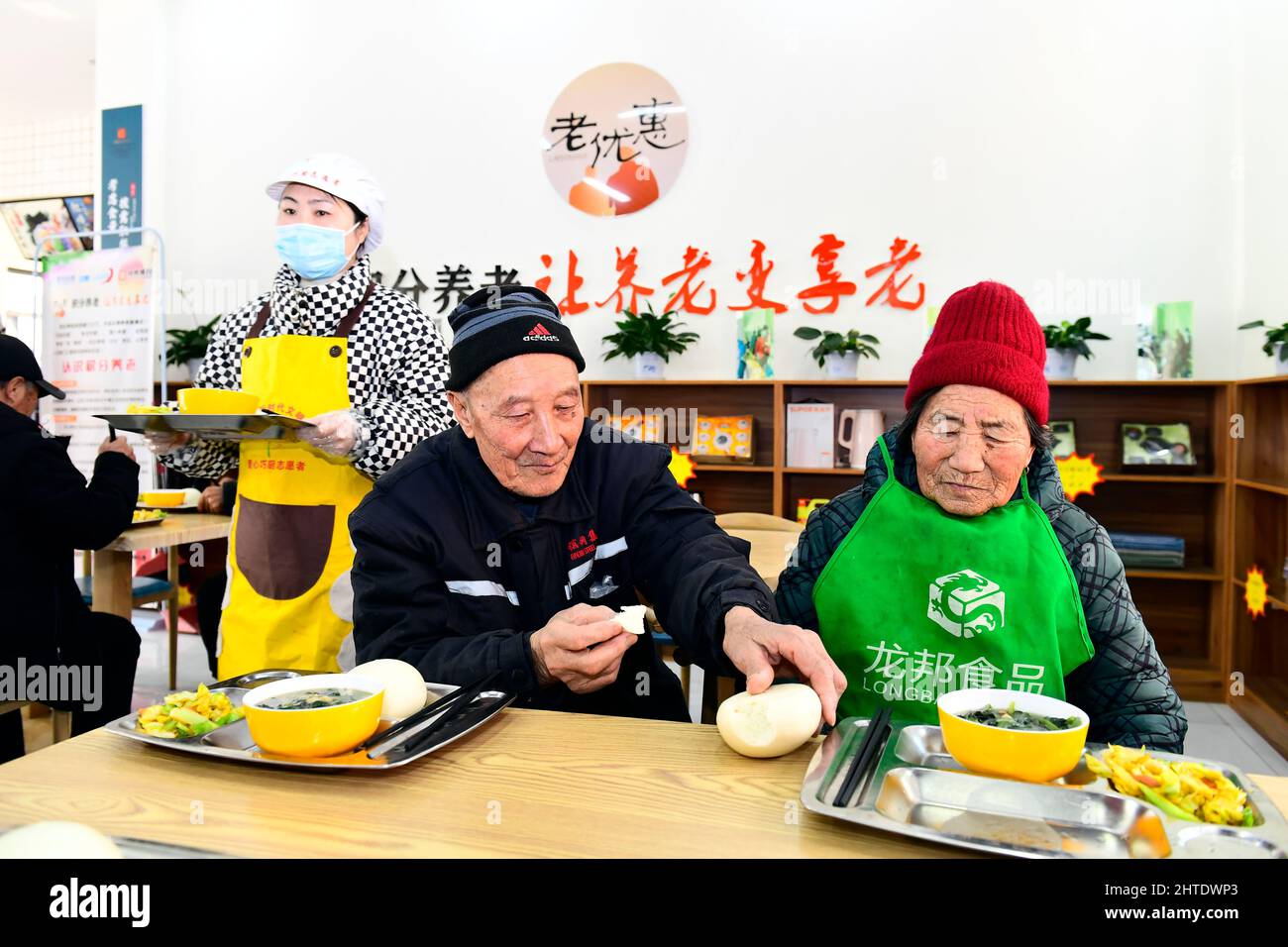 JINAN, le 28 février 2022 (Xinhua) -- les personnes âgées profitent de leur déjeuner dans un centre de soins communautaires pour les personnes âgées du district de Lanshan, Rizhao, province de Shandong en Chine orientale, le 27 février 2022. Le district de Lanshan de la ville de Rizhao a mis en place des centres de soins depuis 2021, fournissant assistance et soins aux personnes âgées de plus de 60 ans. (Xinhua/Guo Xulei) Banque D'Images