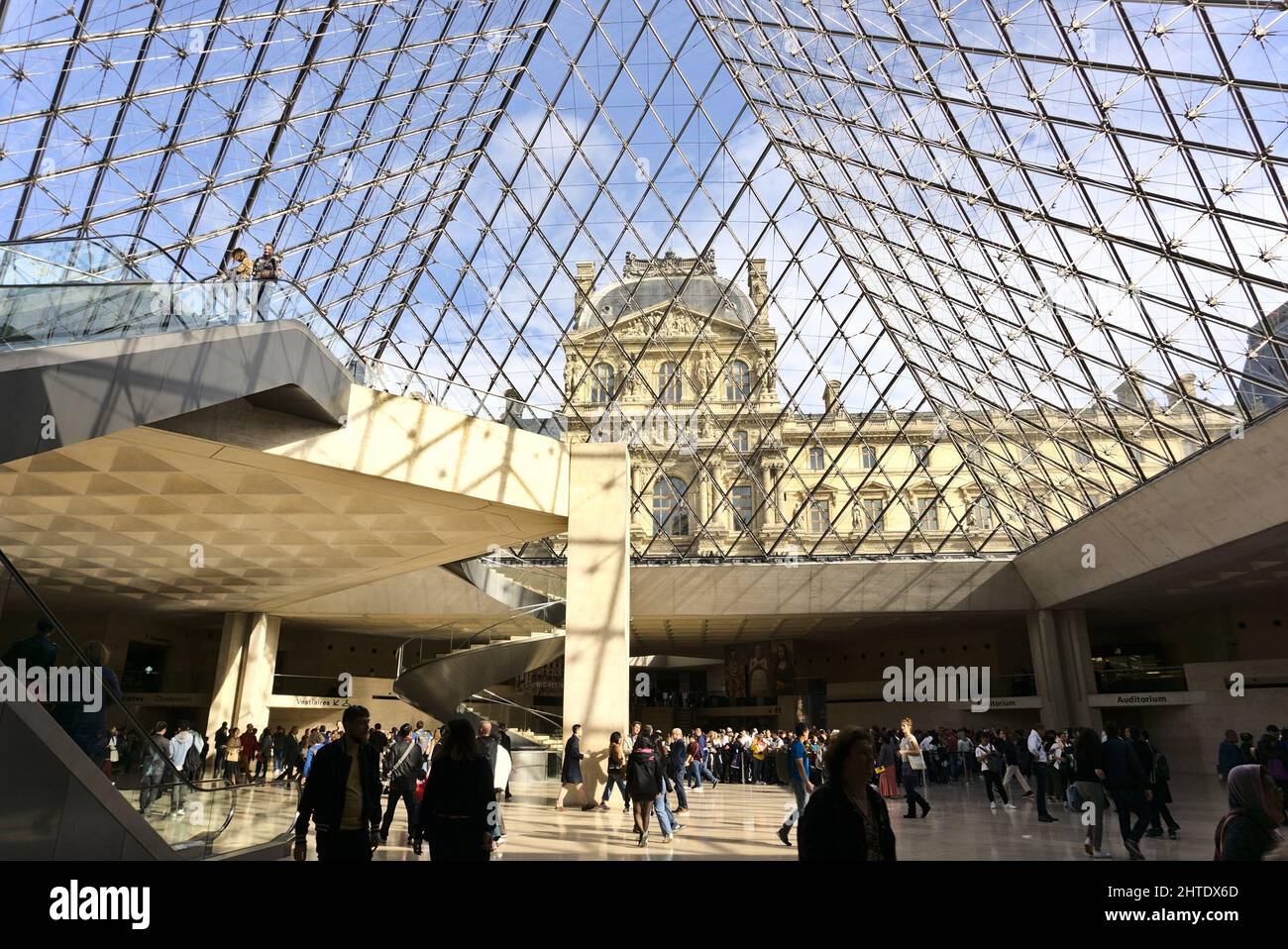 La salle principale pleine de personnes sous la pyramide de verre dans le Musée du Louvre, Paris, France Banque D'Images