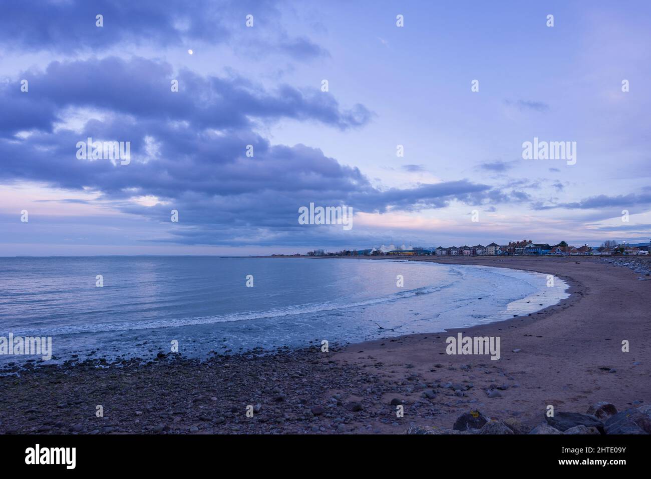 La Lune dans un ciel de crépuscule au-dessus de la plage de Minehead, également connue sous le nom de The Strand, Somerset, Angleterre. Banque D'Images