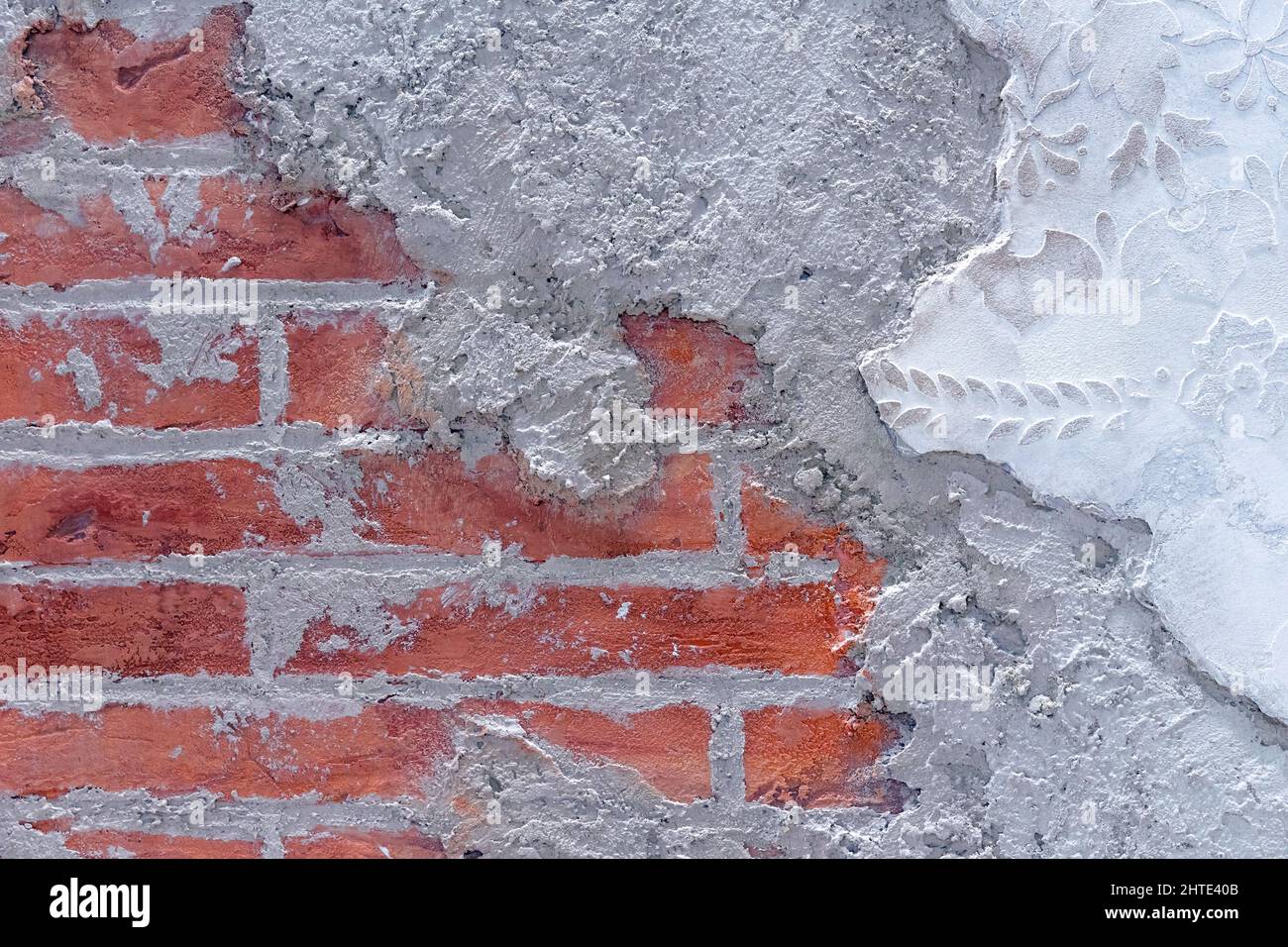 Plâtre endommagé sur fond de mur de brique. Briqueterie sous la surface en béton à texture émiettée. Banque D'Images