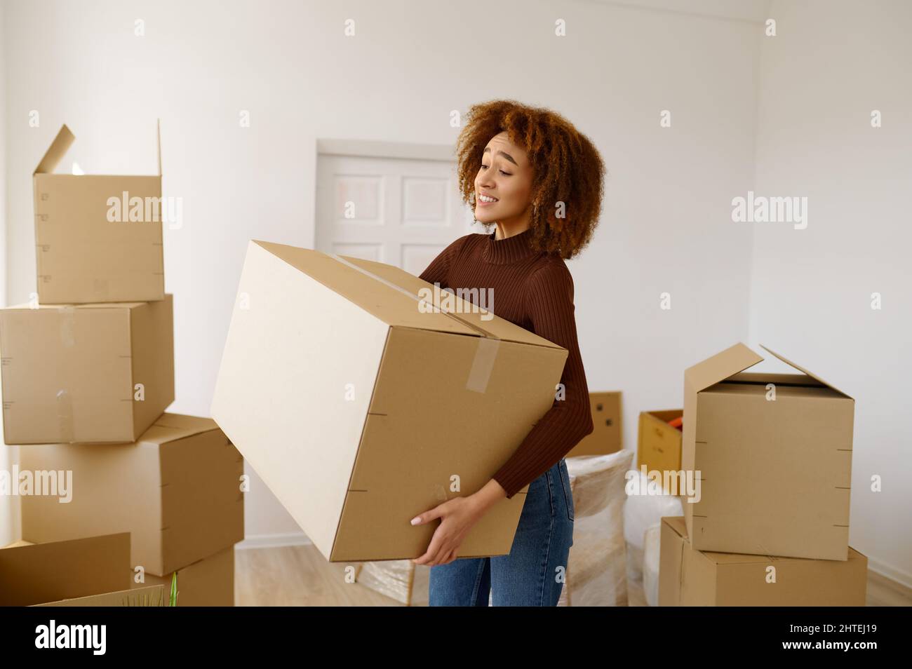 Jeune femme fatiguée debout parmi des boîtes en carton Banque D'Images