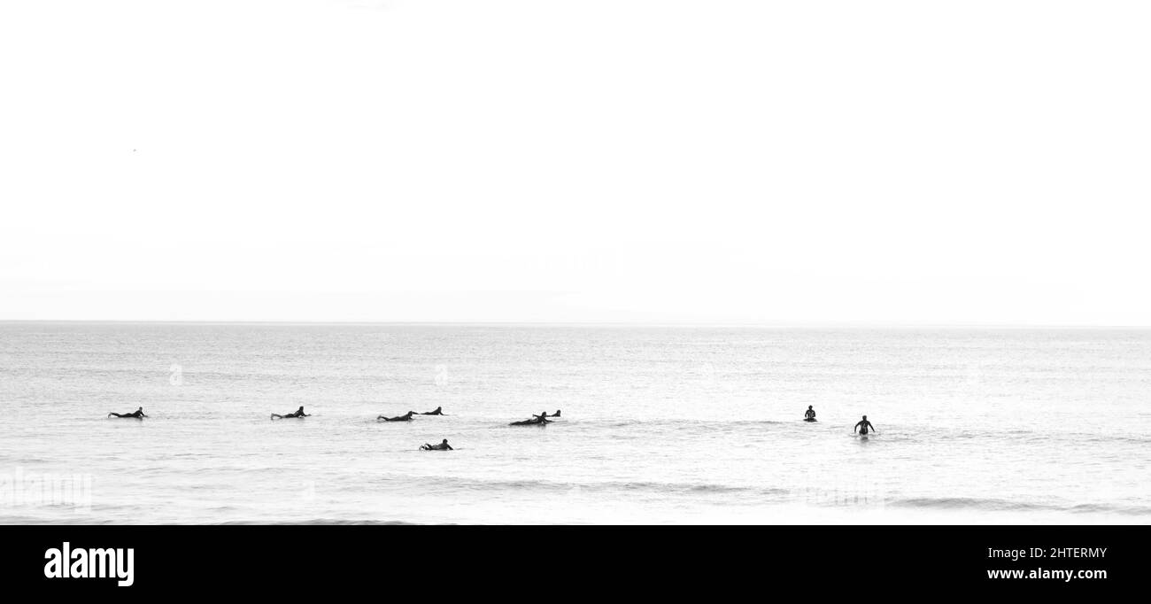 Vue panoramique sur les surfeurs qui surfent sur les vagues par une journée ensoleillée Banque D'Images