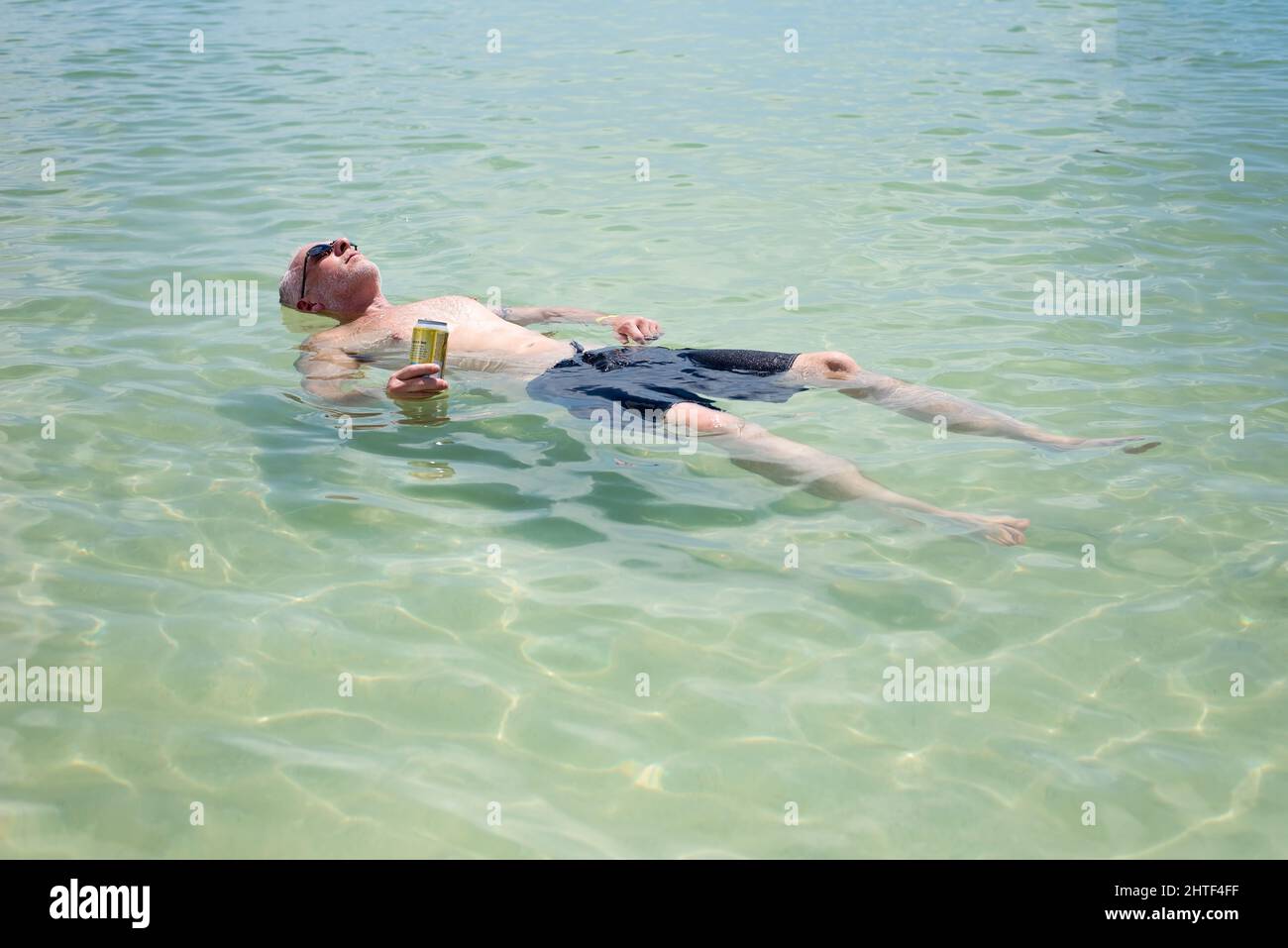 Homme adulte se détendant dans les eaux calmes du golfe lors d'une chaude journée d'été Banque D'Images