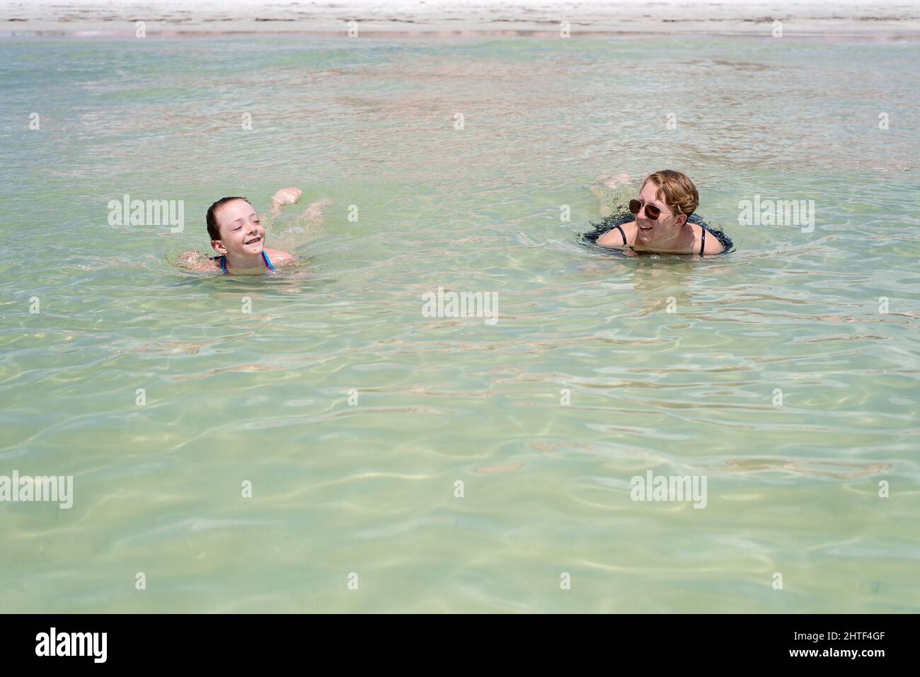 Moment doux entre deux sœurs flottant dans l'eau du golfe Banque D'Images