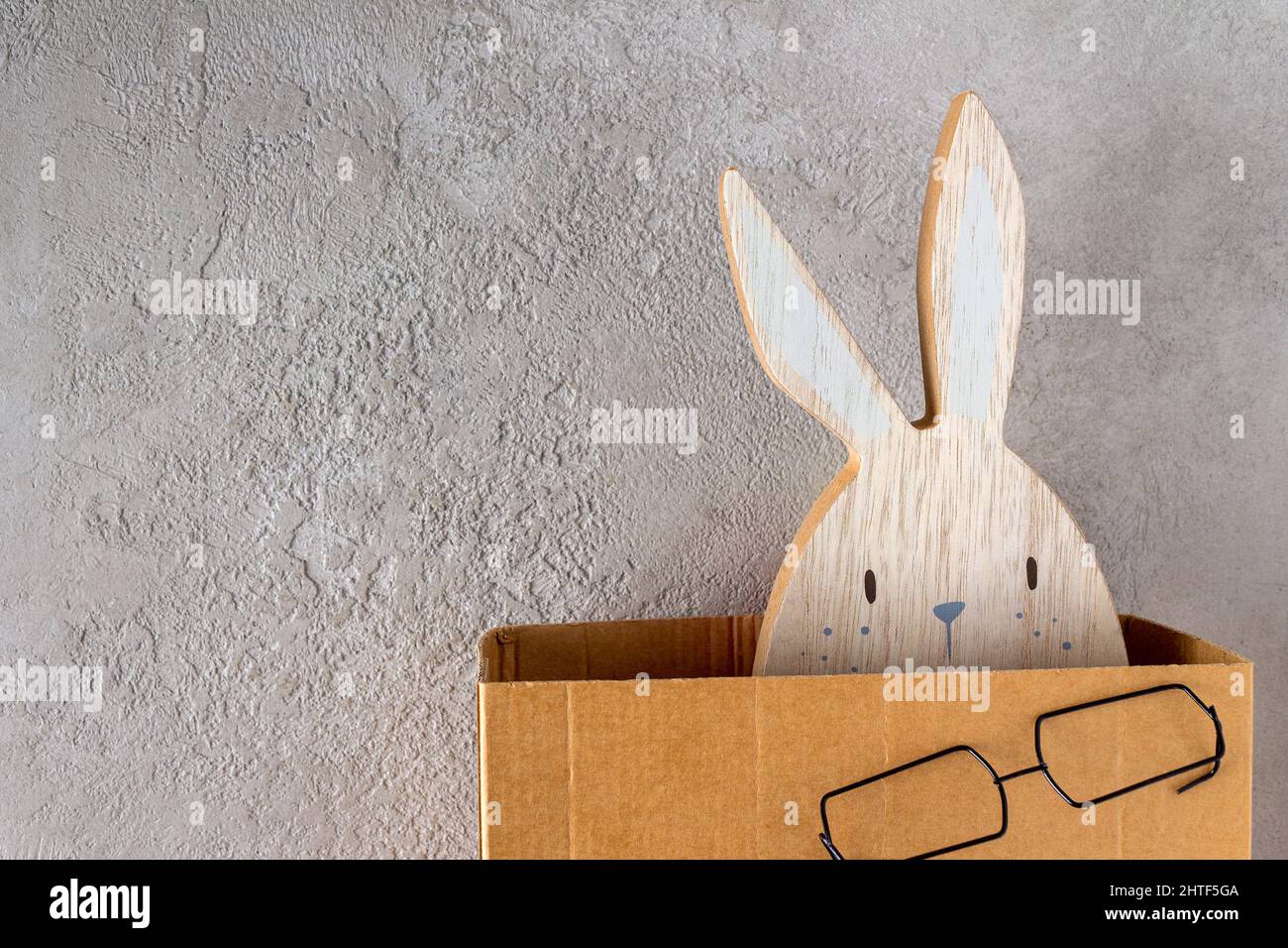 lapin en bois de pâques jetant un coup d'œil hors de la boîte en carton, espace de copie Banque D'Images