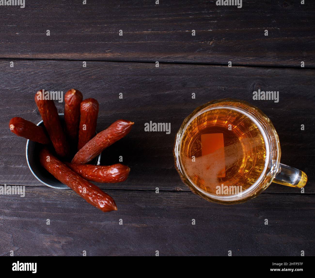 Saucisses avec bière sur fond de bois sombre Banque D'Images