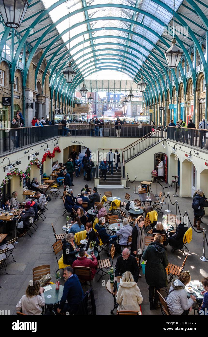 Personnes assises à des tables et des chaises dans un café dans le South Hall à Covent Garden, Londres, Royaume-Uni Banque D'Images