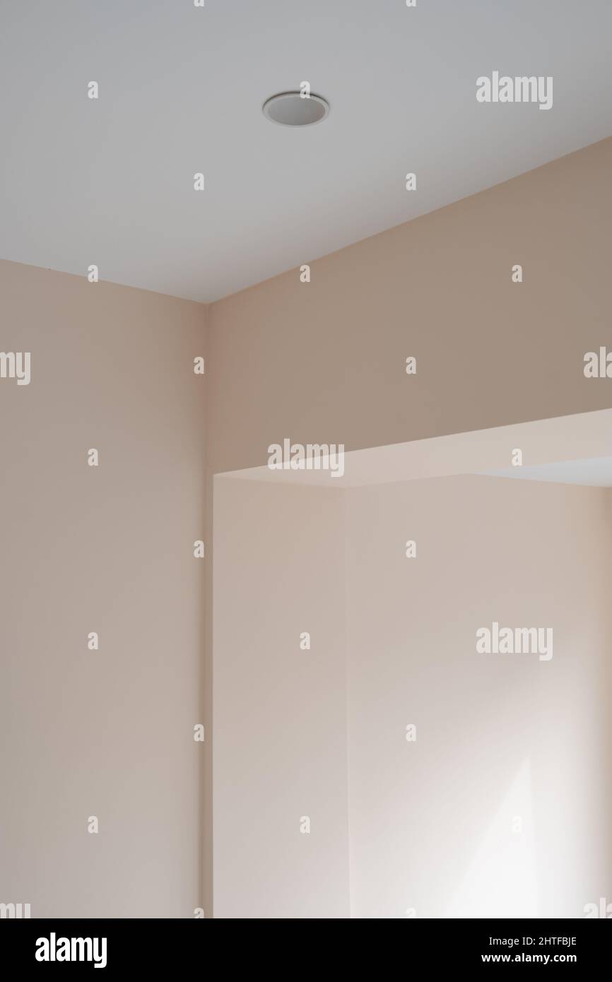 Plan vertical de l'angle supérieur des murs pinky et d'un trou de ventilateur dans le plafond Banque D'Images