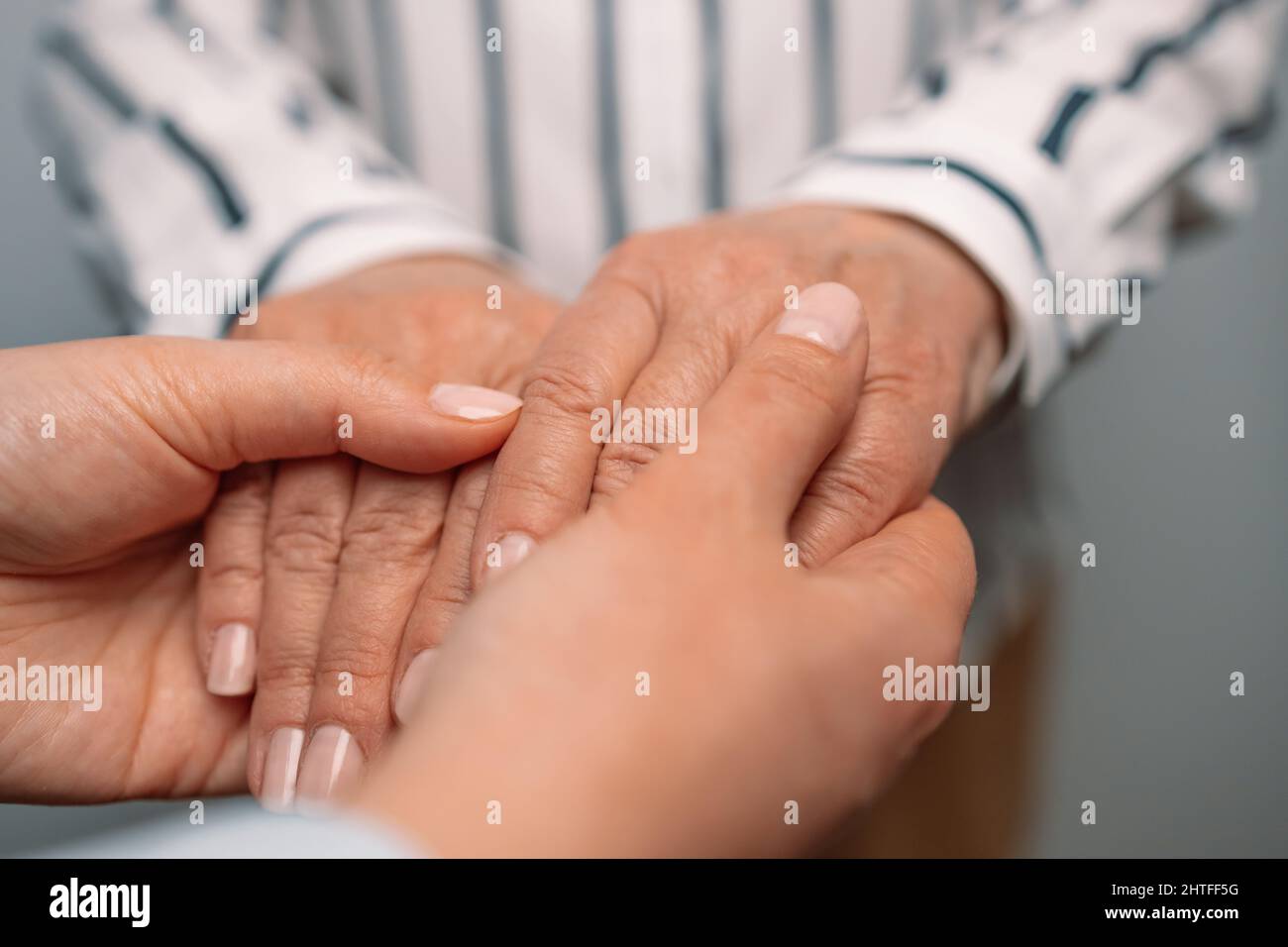 Bonne journée mère. Les aînés et les jeunes tiennent la main pour le confort et la sympathie. Conversation confidentielle avec connexion forte Banque D'Images