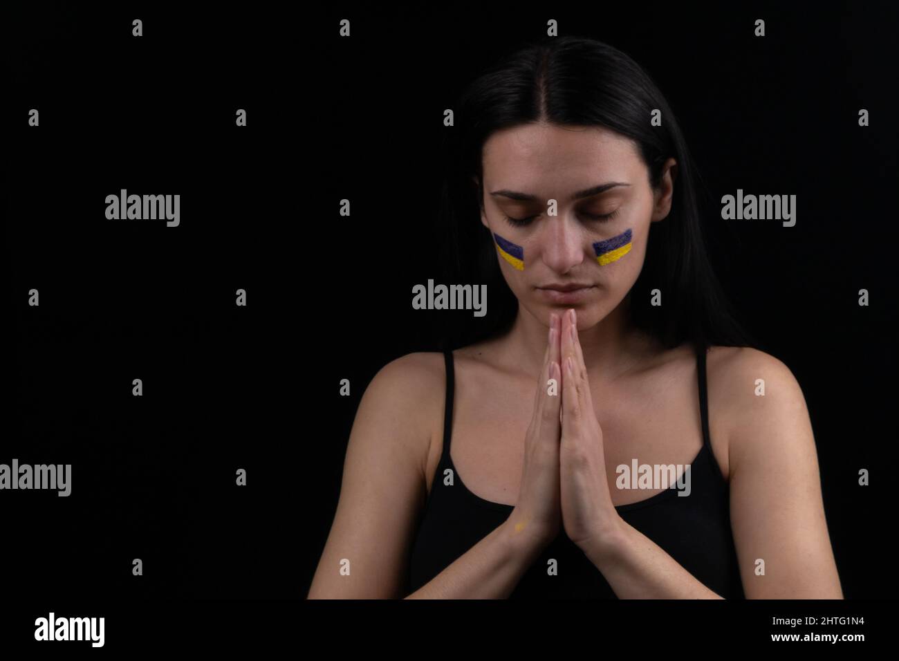 Portrait d'une femme ukrainienne sérieuse avec un drapeau ukrainien bleu et jaune sur sa joue. Le symbole de l'inviolabilité du peuple ukrainien. Ba foncé Banque D'Images