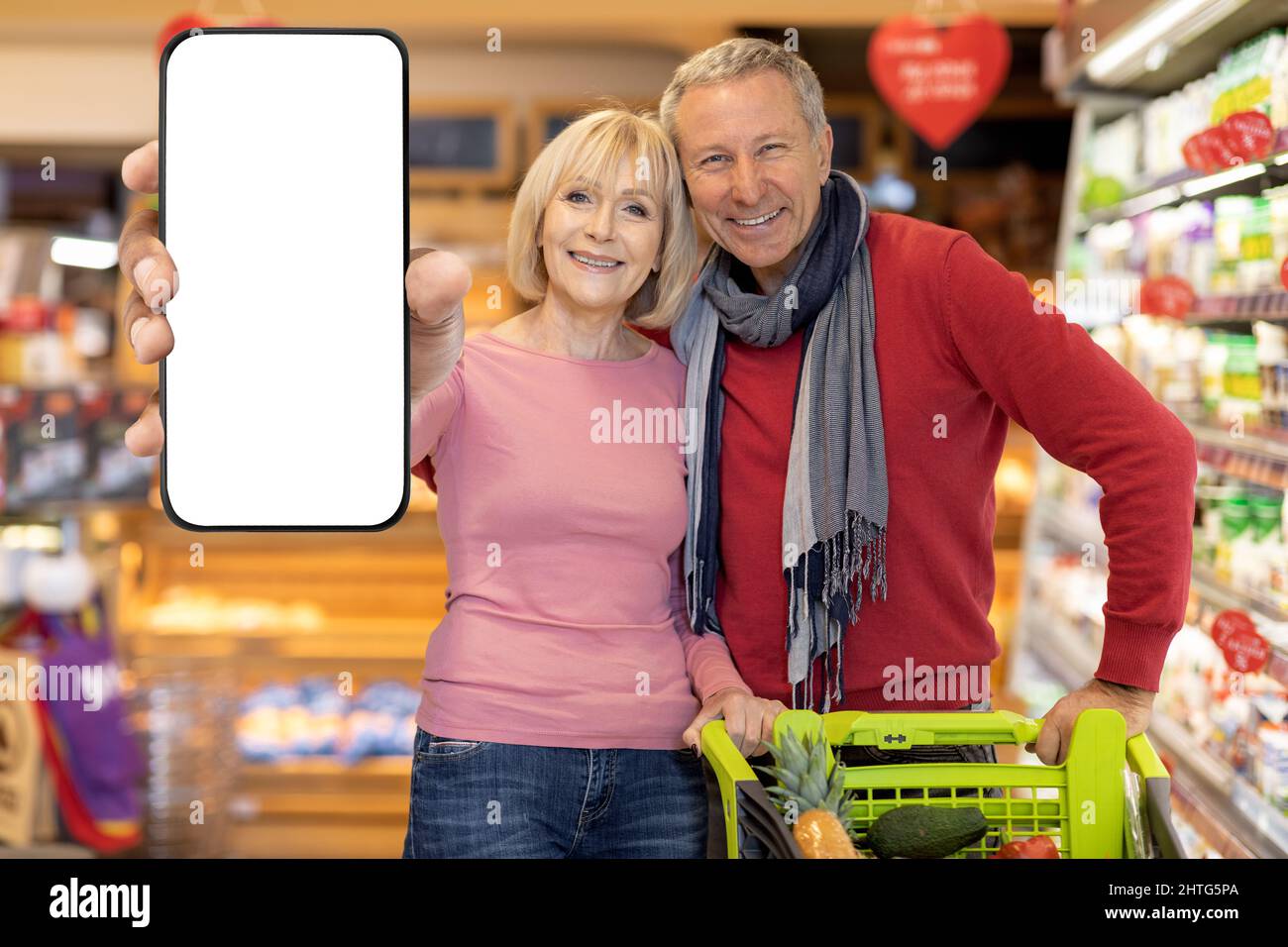 J'aime faire du shopping en couple dans un supermarché, montrer un smartphone, une maquette Banque D'Images