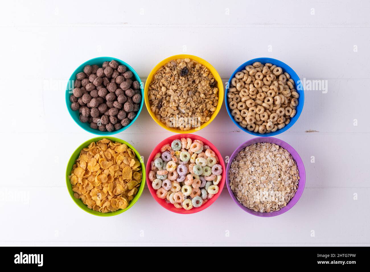 Directement au-dessus d'une dose de différentes céréales pour le petit déjeuner dans des bols colorés disposés sur une table Banque D'Images Directement au-dessus d'une dose de différentes céréales pour le petit déjeuner dans des bols colorés disposés sur une table Banque D'Images