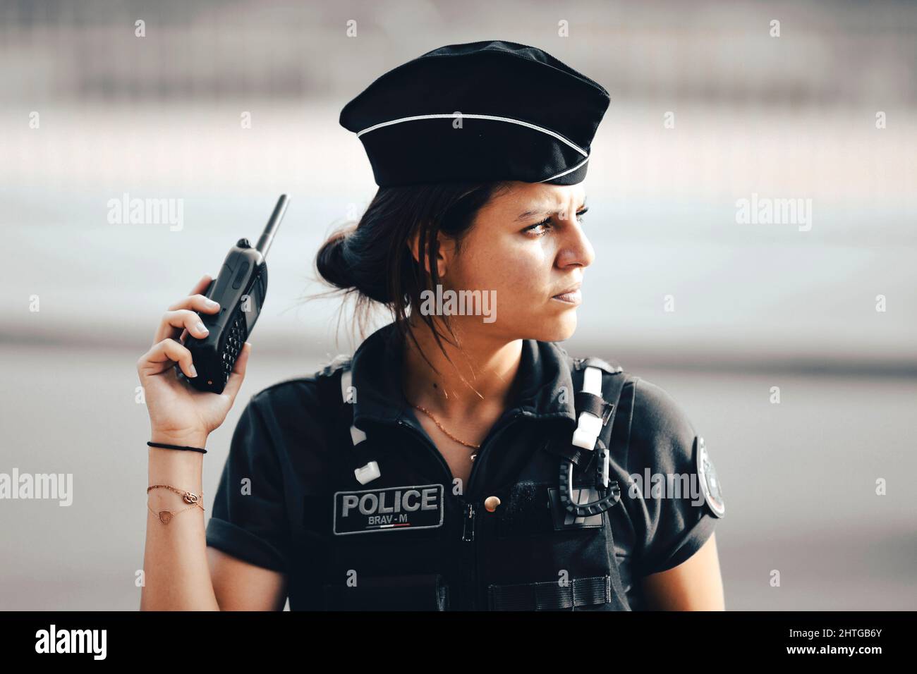 Une femme de police française en service tenant une radio de talkie-walkie  pour communiquer dans sa main assure la sécurité des citoyens dans une rue  parisienne Photo Stock - Alamy