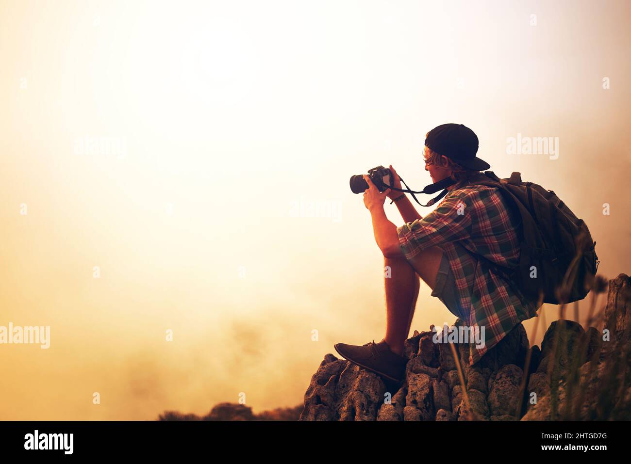 La photographie est une affaire d'amour avec la nature. Photo d'un jeune photographe prenant une photo d'un paysage brumeux depuis le sommet d'une montagne. Banque D'Images