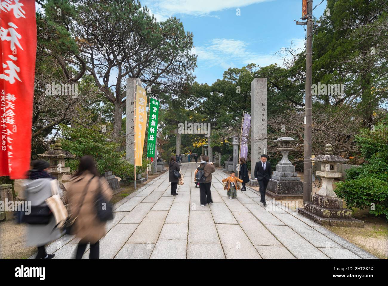 kyushu, japon - décembre 08 2021 : familles japonaises avec enfants dans un kimono sur le chemin sandō du sanctuaire Miyajidake entouré de lanternes en pierre et votive Banque D'Images