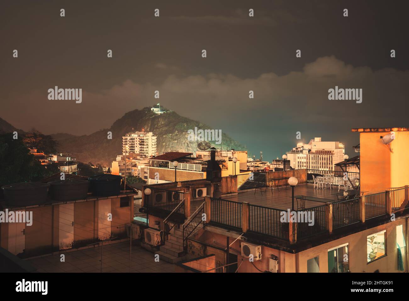 Une nuit, longue exposition photo d'une zone résidentielle de favela à Babilonia, dans le district de Leme de Rio de Janeiro, Brésil, avec de multiples toits éclairés de Banque D'Images